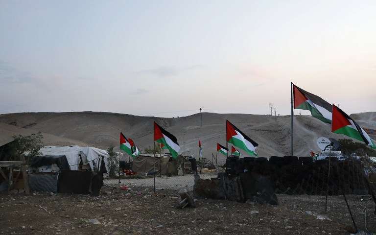 El pueblo beduino árabe de Khan al-Ahmar, al Este de Jerusalén, se ve decorado con banderas palestinas el 2 de octubre de 2018. (AFP PHOTO / AHMAD GHARABLI)