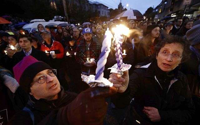 La gente enciende velas mientras se reúnen para una vigilia después de un tiroteo mortal en la Congregación Árbol de la Vida, en el vecindario de Squirrel Hill de Pittsburgh, el sábado 27 de octubre de 2018. (AP / Matt Rourke)