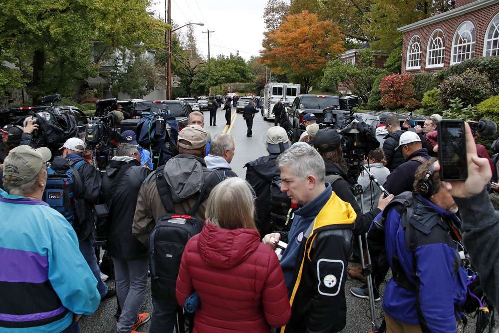 Una multitud de medios de comunicación esperan en la calle a dos cuadras de la Sinagoga Árbol de la Vida en Pittsburgh, donde un tirador mató a 11 personas el sábado 27 de octubre de 2018. (AP / Gene J. Puskar)