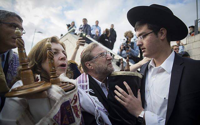 Los judíos ortodoxos intentan evitar que un grupo de rabinos conservadores y reformados estadounidenses y miembros del movimiento Mujeres del Muro traigan rollos de la Torá al recinto del Muro Occidental durante una marcha de protesta contra el fracaso del gobierno para entregar un nuevo espacio de oración en el Muro Occidental en Ciudad Vieja de Jerusalén, 2 de noviembre de 2016. (Hadas Parush / Flash 90)