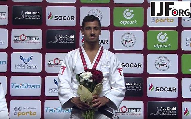 El judoka medallista de oro israelí Tal Flicker se encuentra en el podio en el Grand Slam de Judo en Abu Dhabi, donde las autoridades locales prohibieron la exhibición de todos los símbolos israelíes, el 26 de octubre de 2017. (Captura de pantalla de YouTube)