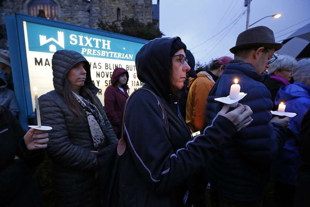 Una multitud sostiene velas en el césped de la Sexta Iglesia Presbiteriana en la intersección de Murray Ave. y la avenida Forbes. en la sección Squirrel Hill de Pittsburgh, Pensilvania, durante una vigilia conmemorativa por las víctimas del tiroteo en la Sinagoga Árbol de la Vida, donde un hombre armado disparó y mató a 11 fieles el sábado 27 de octubre de 201. (AP Photo / Gene J. Puskar)