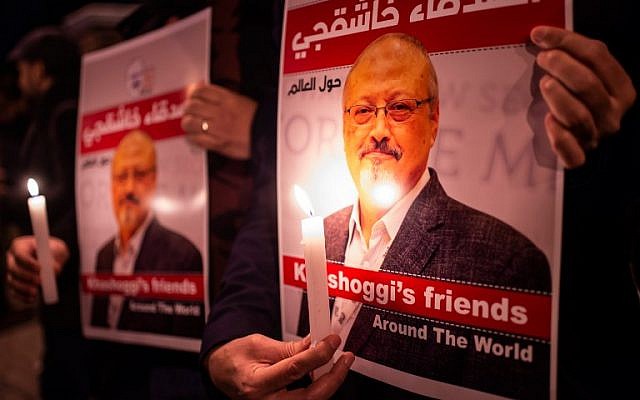 La gente sostiene carteles que representan al periodista saudita Jamal Khashoggi y velas durante una reunión fuera del consulado de Arabia Saudita en Estambul, el 25 de octubre de 2018. (Yasin Akgul / AFP)