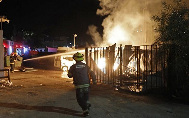 Las fuerzas de seguridad y los bomberos israelíes se reúnen cerca de un edificio incendiado después de que un cohete disparó desde la Franja de Gaza, en la ciudad de Sderot, al sur del 12 de noviembre de 2018. (Menahem KAHANA / AFP)