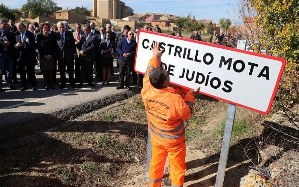 Los funcionarios observan a un empleado que está colocando una señal de tráfico que lee el nuevo nombre del pueblo español 'Castrillo Mota de Judios' que significa 'Montículo de judíos de Castrillo' en la entrada de Castrillo Mota de Judios, cerca de Burgos el 23 de octubre de 2015 (AFP FOTO / CESAR MANSO)