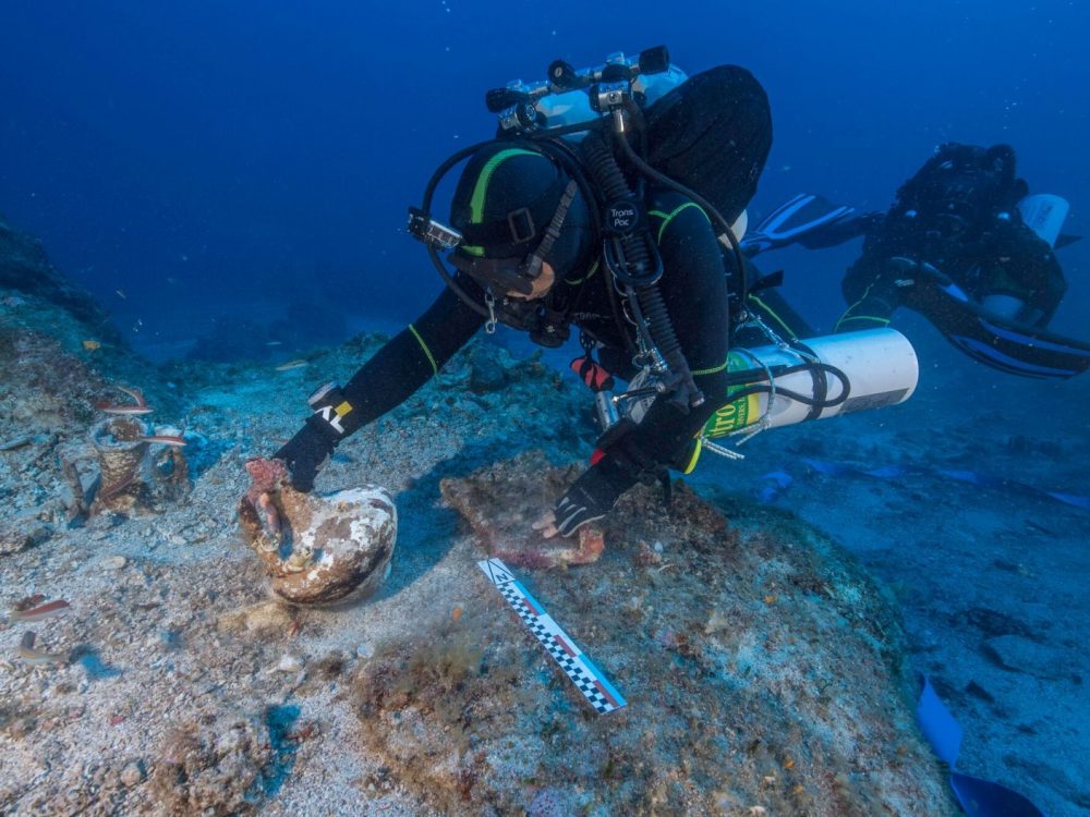 Buceador que levanta ánfora que posiblemente contenía vino o perfume del naufragio de Antikythera Brett Seymour