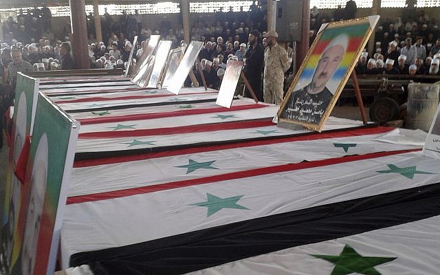 En esta foto publicada por la agencia de noticias oficial siria SANA, los dolientes de la comunidad drusa asisten a un funeral masivo de personas asesinadas el día anterior por una serie de atentados suicidas lanzados por combatientes del Estado Islámico en el campo este y norte de la provincia sur de Al-Sweida, Siria, el 26 de julio de 2018. (SANA a través de AP)
