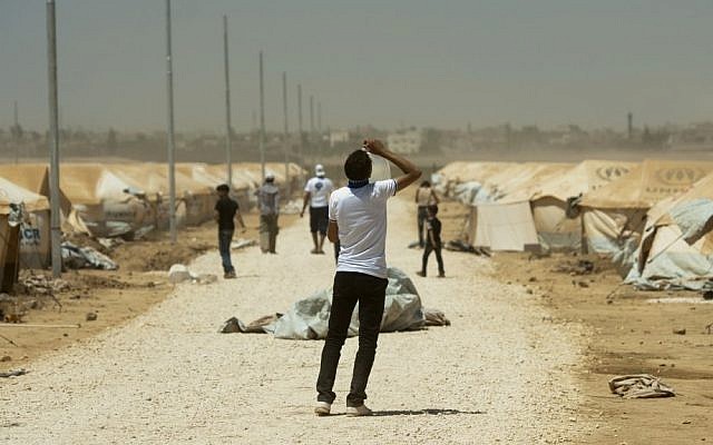 Un refugiado sirio bebe agua en el campamento de refugiados de Zaatari en Jordania, 13 de agosto de 2012. (Crédito de la foto: AP / Clemens Bilan)