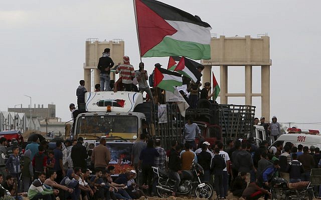 Ilustrativo: Los palestinos ondean banderas mientras viajan en un camión lleno con neumáticos cerca de la frontera de la Franja de Gaza con Israel al este de la ciudad de Gaza, viernes 26 de octubre de 2018. (AP / Adel Hana)