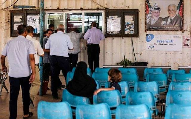 Árabes esperan mientras otros presentan documentos de viaje a los oficiales de la Autoridad Palestina en el cruce de Erez con Israel cerca de Beit Hanoun en el norte de la Franja de Gaza el 27 de agosto de 2018. (AFP Photo / Mahmud Hams)