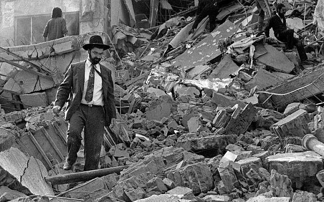 Un hombre camina sobre los escombros después de que explotara una bomba en la Asociación Mutual Israelita Argentina (AMIA) en Buenos Aires, Argentina, 18 de julio de 1994. (AFP / Ali Burafi)