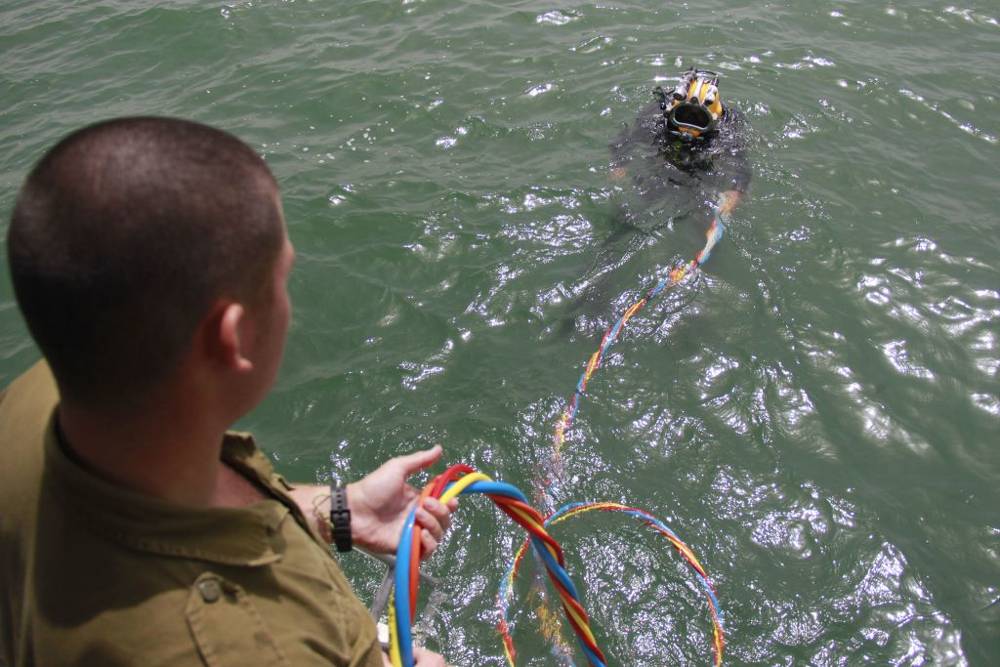 Soldados de Israel tamizan a través del lodo del fondo del Mar de Galilea como parte de una búsqueda del teniente Yakir Naveh, cuyo avión se estrelló en 1962. (Fuerzas de Defensa de Israel)