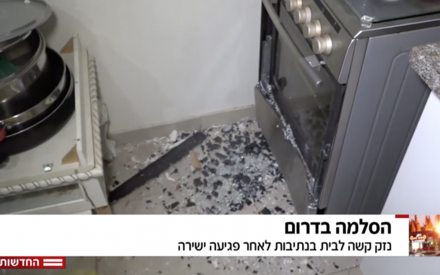 El reportero de Hadashot TV Moshe Nussbaum muestra que un trozo de metralla de un cohete de Hamás se estrelló contra un horno y se detuvo en una casa en Netivot, 12 de noviembre de 2018. (Noticias de Hadashot TV)