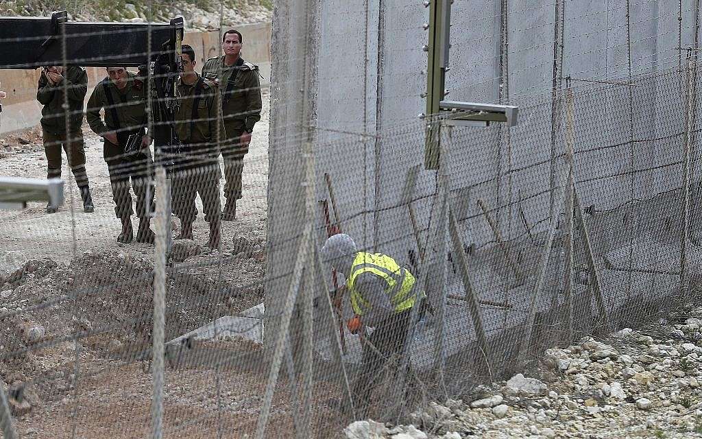 Soldados israelíes observan a un obrero de la construcción construir un muro a lo largo de la frontera israelí en la ciudad costera de Naqoura, sur del Líbano, 8 de febrero de 2018. (AP / Hussein Malla, archivo)