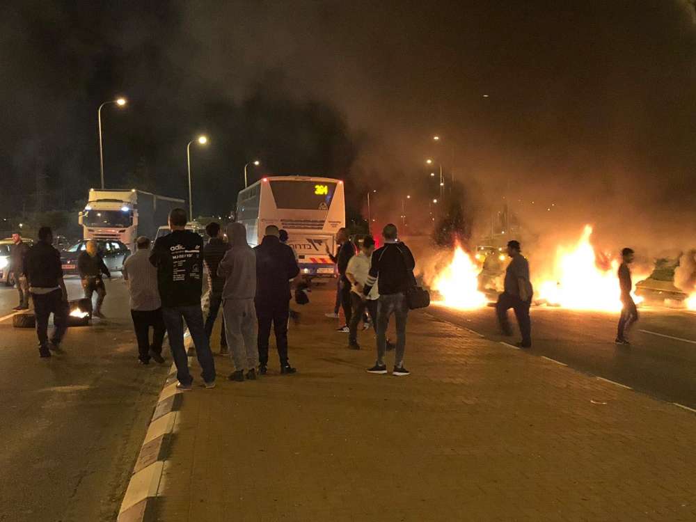 Residentes de comunidades israelíes cerca de la Franja de Gaza queman neumáticos y bloquean una carretera en la entrada a la ciudad de Sderot en protesta por un acuerdo de alto el fuego, 14 de noviembre de 2018. (Policía de Israel)