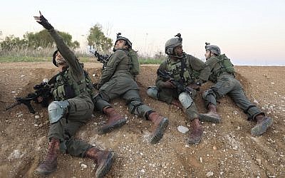 Soldados israelíes se cubren cerca de la frontera entre Israel y Gaza, 12 de noviembre de 2018. (AP Photo / Tsafrir Abayov)