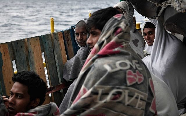 Los migrantes se sientan a bordo de MV Aquarius, un barco de rescate fletado por SOS-Mediterranee y Doctors Without Borders (MSF), en el mar Mediterráneo entre Libia e Italia el 9 de mayo de 2018. (AFP PHOTO / LOUISA GOULIAMAKI)