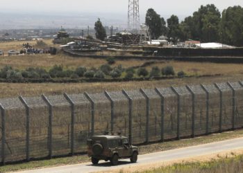 Una fotografía tomada el 4 de julio de 2018 desde los Altos del Golán muestra a sirios desplazados de la provincia de Daraa realizando una protesta (parte superior L) que reclama protección internacional, en la aldea siria de al-Rafid, cerca de la frontera con Israel. (AFP / Jalaa Marey)