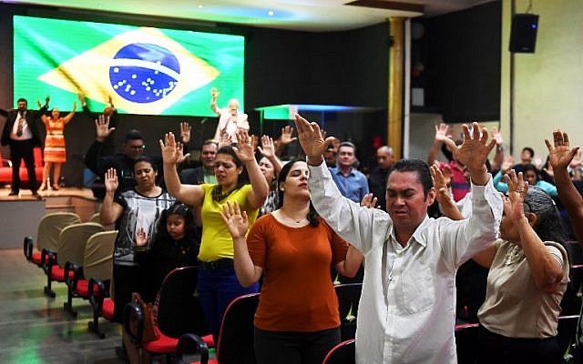 ARCHIVO - En esta foto tomada el 21 de septiembre de 2018, los fieles rezan en una iglesia evangélica en Brasilia por la recuperación del candidato presidencial brasileño de derecha Jair Bolsonaro, quien sufrió un ataque con un cuchillo durante un mitin de campaña (AFP PHOTO / EVARISTO SA)