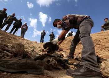 En esta foto de archivo tomada el 3 de febrero de 2015, los yazidis buscan familiares desaparecidos en los restos de personas asesinadas por jihadistas del Estado Islámico cerca de la aldea iraquí de Sinuni. (Safin Hamed / AFP)