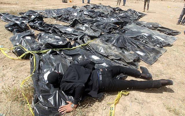 En esta foto tomada el 12 de abril de 2015, un hombre iraquí llora sobre bolsas de cadáveres que contienen los restos de personas que se cree fueron asesinadas por jihadistas del Estado Islámico en el campamento de Speicher en la ciudad iraquí de Tikrit. (Ahmad Al-Rubaye / AFP)