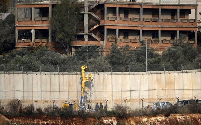 Soldados israelíes de pie junto a la maquinaria de excavación cerca del muro fronterizo con el Líbano en el área de Metulla, 4 de diciembre de 2018. (JALAA MAREY / AFP)