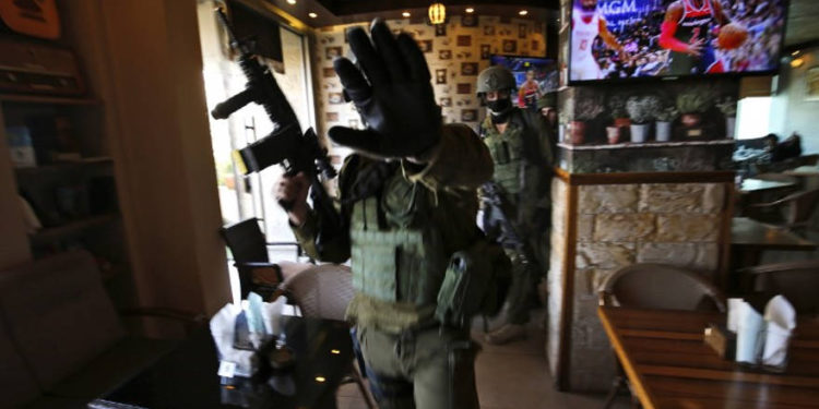 Los soldados israelíes permanecen en el interior de un restaurante durante una redada en la ciudad de Ramallah, en Cisjordania, el 10 de diciembre de 2018, luego de un ataque con disparos desde un vehículo junto al asentamiento del día anterior en el que resultaron heridos muchos israelíes. (ABBAS MOMANI / AFP)