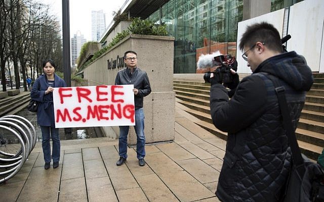 Ada Yu, a la izquierda, de Vancouver y un hombre que deseaba permanecer sin identificar, sostienen un letrero a favor de la liberación de la Directora Financiera de Huawei Technologies, Meng Wanzhou, fuera de su audiencia de fianza en los Tribunales Superiores de la Columbia Británica luego de su arresto en Canadá por extradición a los EE. UU. en Vancouver, Columbia Británica, el 10 de diciembre de 2018. (Jason Redmond / AFP)