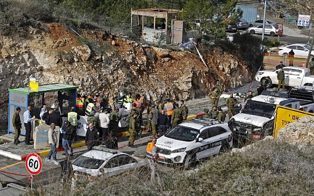 Las fuerzas de seguridad israelíes y los expertos forenses inspeccionan la escena de un tiroteo terrorista en el exterior del asentamiento de Givat Asaf, al noreste de la ciudad cisjordana de Ramallah, el 13 de diciembre de 2018. (Ahmad Gharabli / AFP)