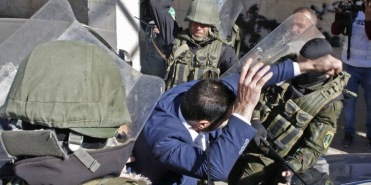 Las fuerzas de seguridad palestinas golpearon a un partidario de Hamas cuando intentaban dispersar una manifestación que conmemora el 31 aniversario de la fundación del grupo terrorista en Hebrón el 14 de diciembre de 2018. (Hazem Bader / AFP)