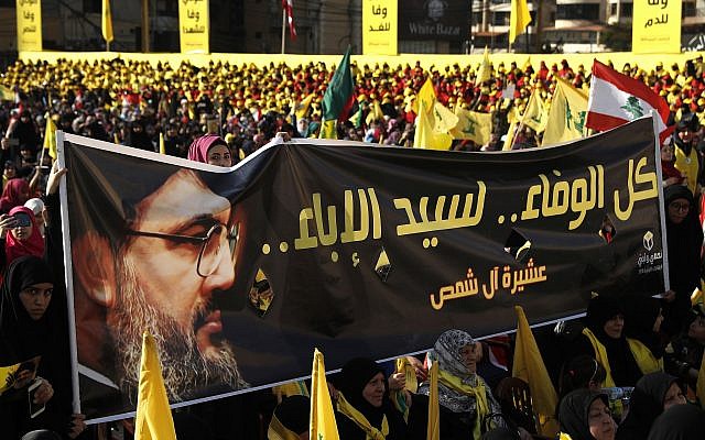 Los partidarios del líder de Hezbolá, Hassan Nasrallah, sostienen una pancarta con su retrato y palabras en árabe que dicen: 'Toda la lealtad al hombre de la nobleza' durante un discurso de campaña electoral, en un suburbio del sur de Beirut, Líbano, el 13 de abril de 2018. (AP / Hussein Malla / Archivo)