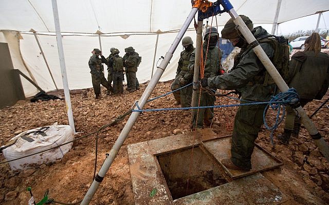 Los soldados israelíes están parados alrededor de la apertura de un agujero que conduce a un túnel que el ejército dice que fue excavado por el grupo terrorista Hezbolá a través de la frontera entre Israel y el Líbano, cerca de Metula, el 19 de diciembre de 2018. (AP Photo / Sebastian Scheiner)