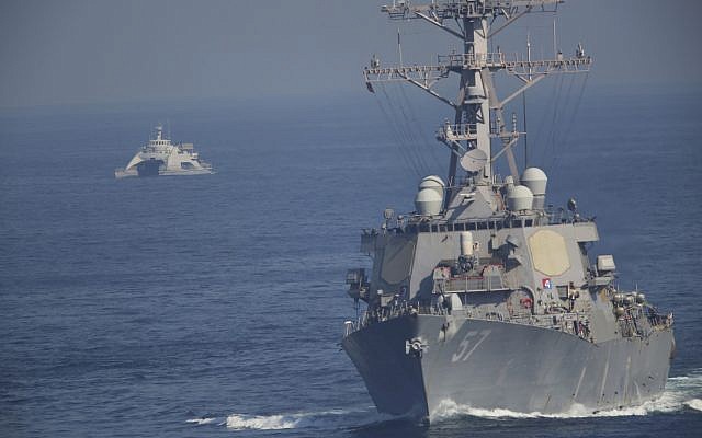 El USS Mitscher, parte de un grupo de ataque liderado por el portaaviones USS John C. Stennis, navega mientras un barco de la Guardia Revolucionaria Iraní lo oculta el 21 de diciembre de 2018. (AP Photo / Jon Gambrell)