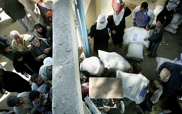 Los palestinos reciben sus suministros mensuales de alimentos del Programa Mundial de Alimentos en la ciudad de Gaza, 4 de marzo de 2006 (Foto AP / Hatem Moussa)