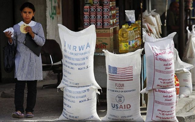 Un estudiante palestino pasa por delante del Organismo de Obras Públicas y Socorro de las Naciones Unidas (OOPS) y la ayuda humanitaria de la USAID el 6 de junio de 2010 en el campamento de refugiados de Shatie, en la ciudad de Gaza. (Foto AP / Lefteris Pitarakis, Archivo)