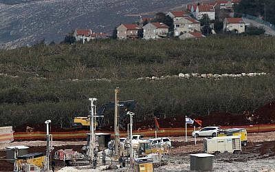 En esta foto del 13 de diciembre de 2018, el equipo militar israelí trabaja en la frontera libanesa-israelí frente a la ciudad israelí de Metula, al fondo, cerca de la aldea sureña de Kafr Kila, en el Líbano. (Foto AP / Hussein Malla)