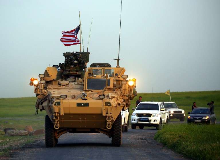 Las fuerzas estadounidenses, acompañadas por combatientes de las Unidades de Protección de los Pueblos Kurdos (YPG), conducen sus vehículos blindados cerca de la aldea siria de Darbasiyah, en la frontera con Turquía, 28 de abril de 2017. (DELIL SOULEIMAN / AFP)