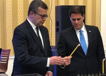 El embajador israelí en los Estados Unidos, Ron Dermer, enciende la menorá en la segunda noche de Hanukkah con la ayuda del embajador polaco en los Estados Unidos, Piotr Wilczek, en la embajada de Polonia en Washington, DC, el 3 de diciembre de 2018. Crédito: Embajador Ron Dermer /Gorjeo.