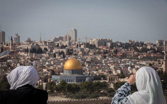Los turistas miran la vista de la Cúpula de la Roca y el Monte del Templo desde el mirador del Monte de los Olivos que domina la ciudad vieja de Jerusalén, el 28 de noviembre de 2018. (Yonatan Sindel / Flash90)