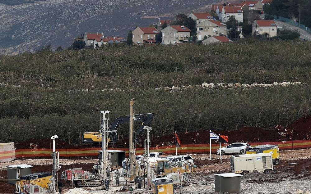 En este jueves, 13 de diciembre de 2018, foto, equipo militar israelí trabaja en la frontera entre el Líbano e Israel frente a la ciudad israelí de Metula, al fondo, cerca de la aldea sur de Kafr Kila, en el Líbano. (Foto AP / Hussein Malla)