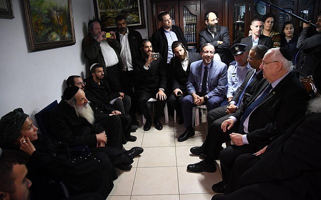 El presidente Reuven Rivlin, a la derecha, visita a la familia del soldado Yosef Cohen, asesinado en un ataque terrorista en el cruce de Givat Assad en la Ribera Occidental, en Jerusalén, el 18 de diciembre de 2018. (Haim Zach / GPO)