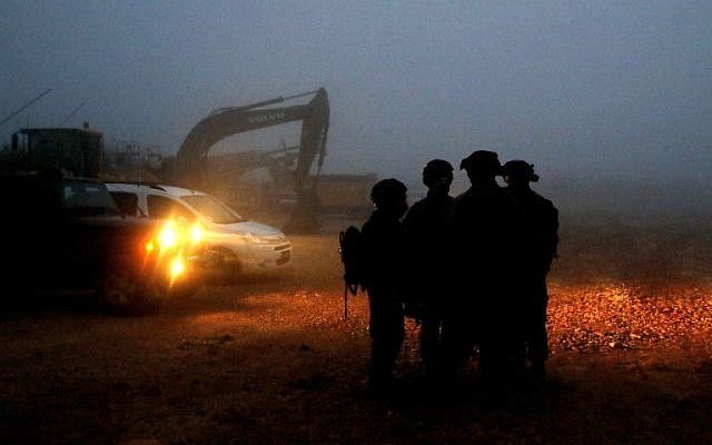 Los soldados israelíes se reúnen cerca del equipo de excavación utilizado para localizar los túneles de ataque de Hezbolá a lo largo de la frontera con el Líbano, cerca de la ciudad de Metula, en el norte de Israel, el 19 de diciembre de 2018. (Jack Guez / AFP)