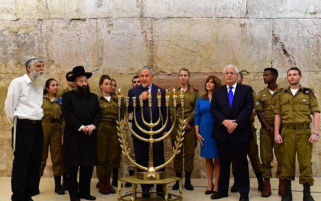 El primer ministro Benjamin Netanyahu se unió al embajador de los Estados Unidos en Israel, David M. Friedman, y a su esposa Tammy en el Muro Occidental de Jerusalén para una ceremonia de encendido de velas que conmemora la quinta noche de Hanukkah con motivo de un año desde la declaración del 6 de diciembre de 2017 del presidente Trump sobre el traslado de EE. UU. Embajada en Jerusalén. (Koby Gideon / GPO)