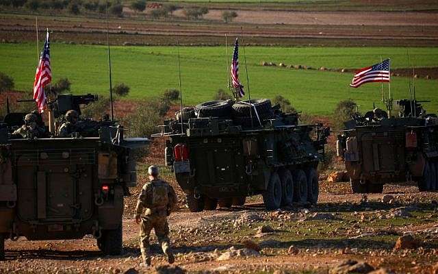 Los vehículos blindados de las fuerzas estadounidenses conducen cerca de la aldea de Yalanli, en las afueras del oeste de la ciudad de Manbij, en el norte de Siria, el 5 de marzo de 2017. (DELIL SOULEIMAN / AFP)