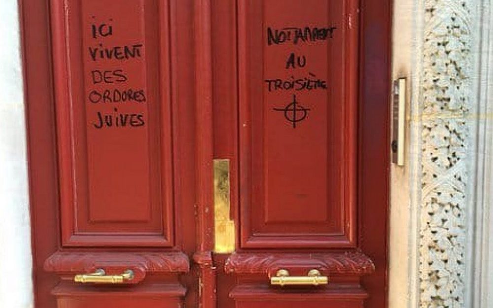 Graffiti antisemita que lee 'La escoria judía vive aquí', en un edificio en París. 'Notablemente en el tercer piso', agrega al otro lado de la puerta, sobre un dibujo de un objetivo. (Gorjeo)