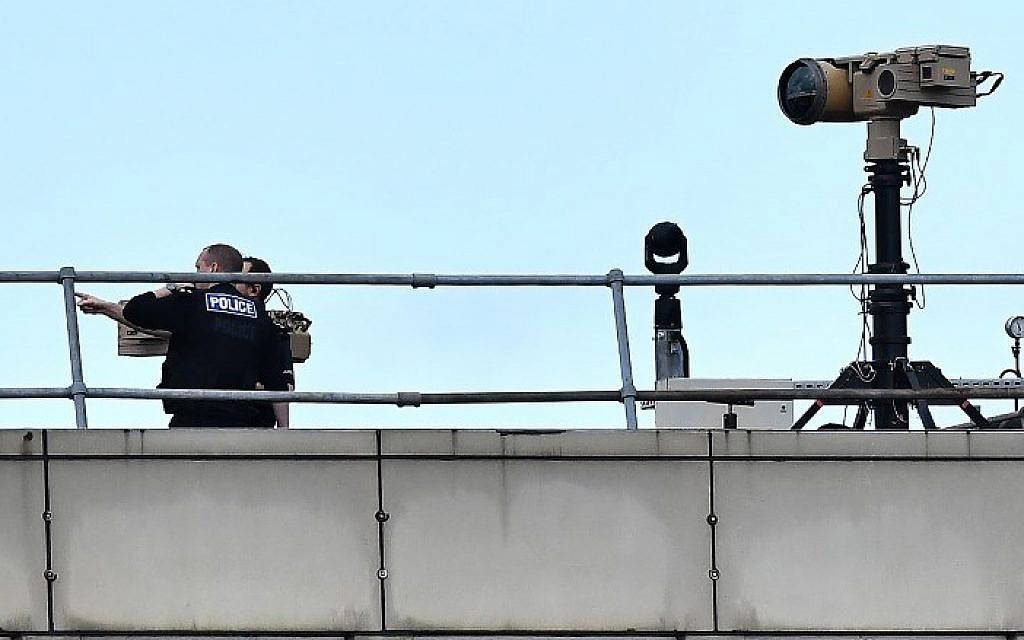 Oficiales de policía cerca del equipo en la azotea de un edificio en el aeropuerto de Londres Gatwick, al sur de Londres, el 21 de diciembre de 2018. (Ben Stansall / AFP)