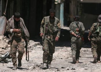 Los combatientes de las Fuerzas Democráticas de Siria (SDF) caminan sobre los escombros de tiendas y edificios dañados en la ciudad de Manbij, en la gobernación de Alepo, Siria, 10 de agosto de 2016. Foto: Reuters / Rodi Said / File.