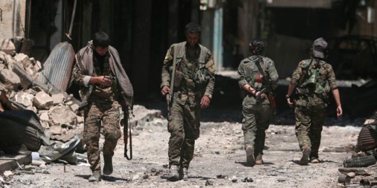 Los combatientes de las Fuerzas Democráticas de Siria (SDF) caminan sobre los escombros de tiendas y edificios dañados en la ciudad de Manbij, en la gobernación de Alepo, Siria, 10 de agosto de 2016. Foto: Reuters / Rodi Said / File.