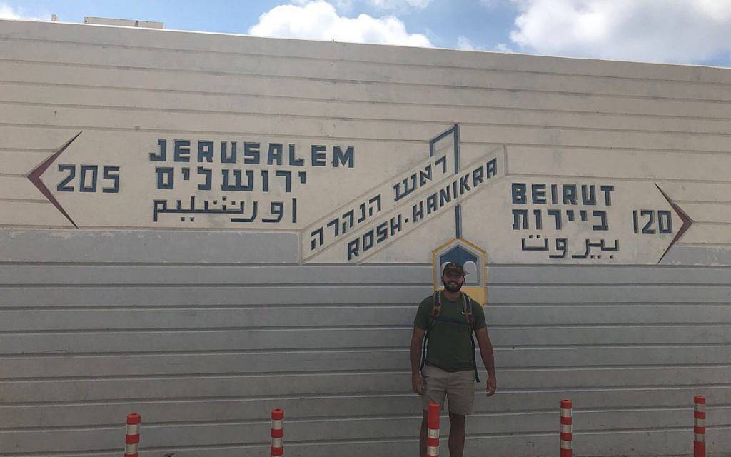 Zachary Zeff se encuentra frente a un cartel que señala a Jerusalén, Rosh Hanikra y Beirut. (Cortesía)