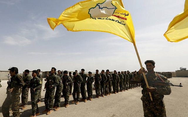 Los miembros de las Fuerzas Democráticas Sirias (SDF), entrenados por la coalición liderada por Estados Unidos, participan en la ceremonia de graduación de su primer regimiento en al-Kasrah, un suburbio de la ciudad oriental de Siria, Deir Ezzor, el 21 de mayo de 2018. ( Foto de AFP / Delil Souleiman)